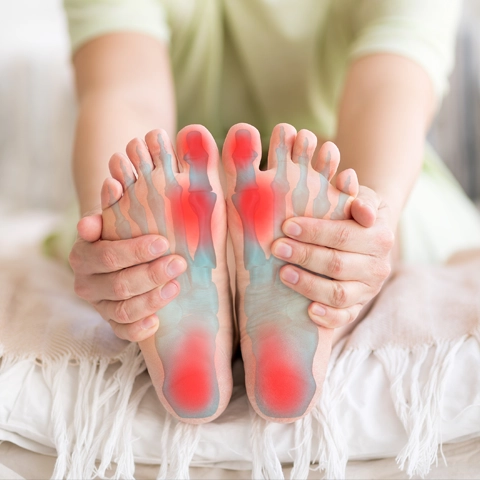 A person holding their feet in pain.