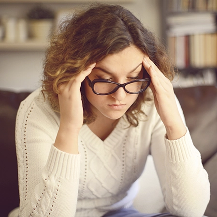 A woman holding her head.