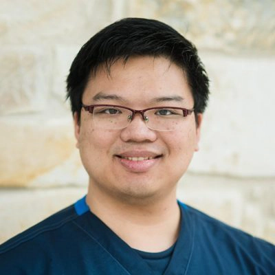 James smiling in front of a stone wall.